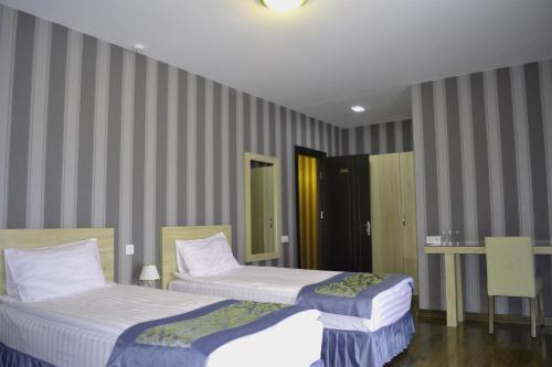 - 2 lits dans une chambre d'hôtel aux murs rayés dans l'établissement Edelweiss Hotel, à Goudaouri