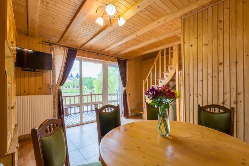 a vase of flowers on a wooden table in a room at Shepilska Relax Complex in Dovholuka