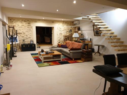 Saint-Gervais的住宿－le clos soleilhan，带沙发和螺旋楼梯的客厅