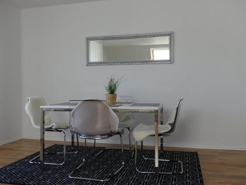 einen Esstisch mit Stühlen und einem Spiegel in der Unterkunft Townflat Kassel City / Privat wie im eigenen Haus / Kostenlos Parken in Kassel
