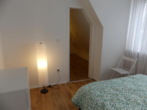 ein Schlafzimmer mit einem Bett, einer Lampe und einem Stuhl in der Unterkunft Townflat Kassel City / Privat wie im eigenen Haus / Kostenlos Parken in Kassel