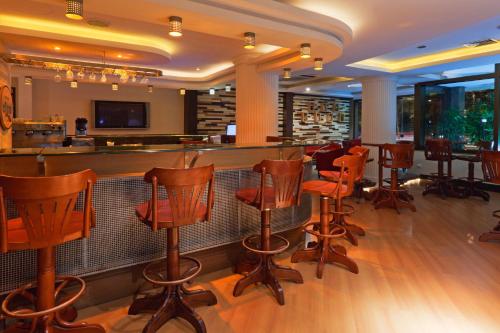 a bar with a row of wooden bar stools at Master Porto Alegre Hotel - Av Carlos Gomes, Próximo ao Consulado Americano in Porto Alegre