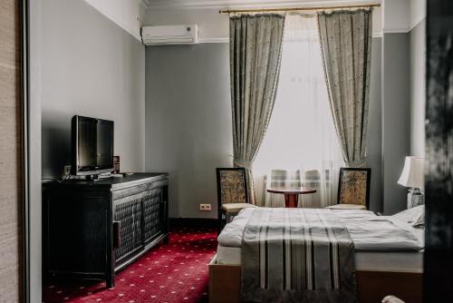 a bedroom with a bed and a tv and a window at Plaza Hotel in Kokshetau