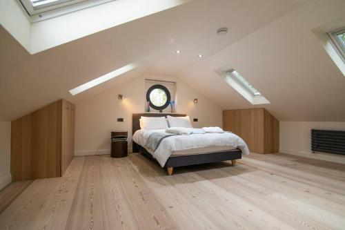 a bedroom with a bed and a clock on the wall at Luxury Coach house next to woodland in Knutsford in Knutsford