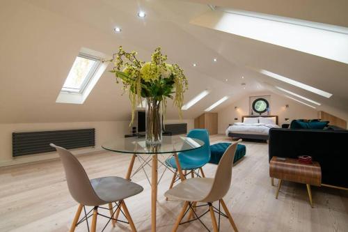 a living room with a table and chairs and a bed at Luxury Coach house next to woodland in Knutsford in Knutsford