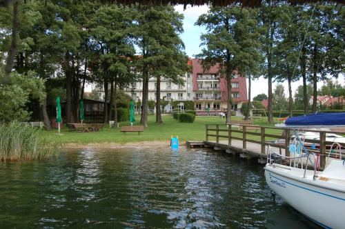 a boat docked at a dock in front of a building at Hotel Europa in Giżycko