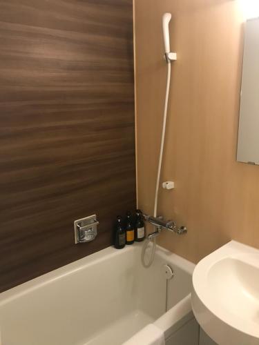 a bathroom with a tub, toilet and sink at Bayside Hotel Azur Takeshiba in Tokyo