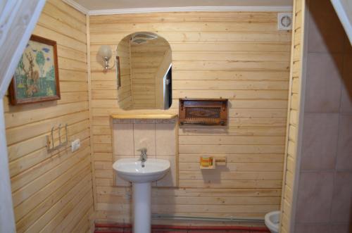 a wooden bathroom with a sink and a mirror at Гуцульська Спадщина in Vorokhta