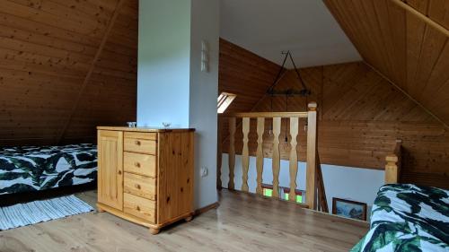 a bedroom with a bed and a staircase in a attic at Domek pod Czulnią in Uherce Mineralne (7)