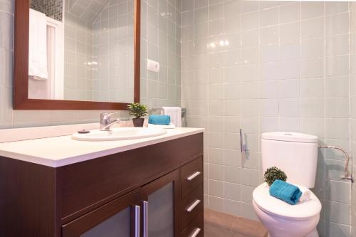 y baño con aseo, lavabo y espejo. en Homes & Go Bell Reco Confort II, en La Pineda