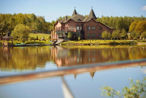 a large house sitting on top of a lake at Shepilska Relax Complex in Dovholuka