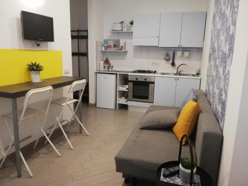 salon z kanapą i kuchnią w obiekcie DIVAS appartamento w mieście Neapol