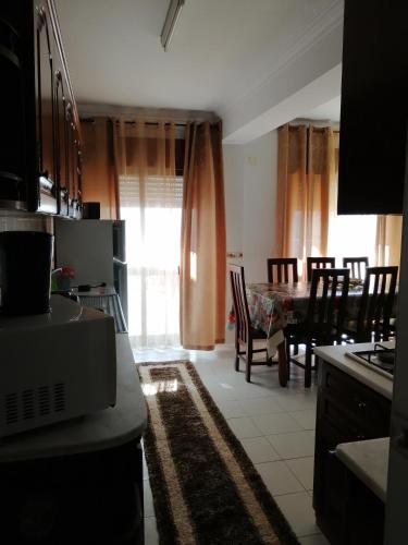 a kitchen and dining room with a table and chairs at apartamentos lazarino1 in Nazaré