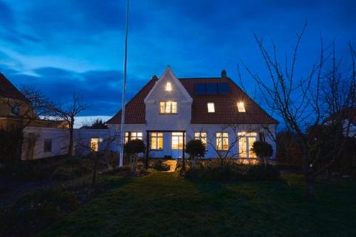 a large house with its lights on in the night at BnB Thuroe in Svendborg