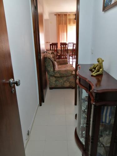 a hallway with a living room with a chair and a table at apartamentos lazarino1 in Nazaré