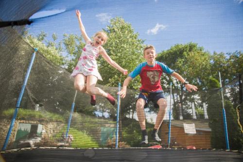 a boy and a girl jumping on a trampoline at Shepilska Relax Complex in Dovholuka
