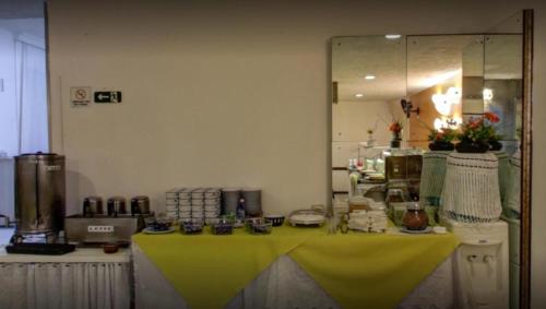 a table with a yellow table cloth in a kitchen at Rede Andrade Guaíra in Curitiba