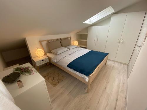 um quarto com uma cama com um cobertor azul em Apartment Vital Nerezine em Nerezine