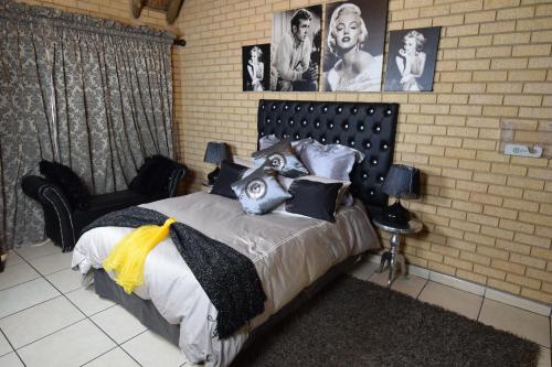 a bedroom with a large bed with pictures on the wall at Thabong Bed and Breakfast in Brakpan
