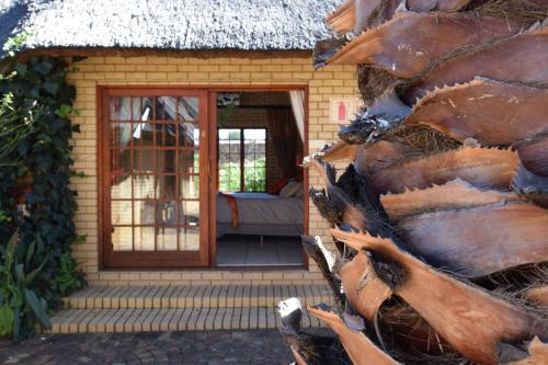 a door of a house with a thatch roof at Thabong Bed and Breakfast in Brakpan