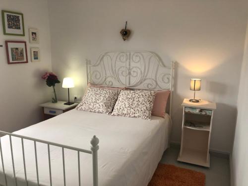 Un dormitorio con una cama blanca con almohadas. en Casa La Mareta, en Casillas del Ángel