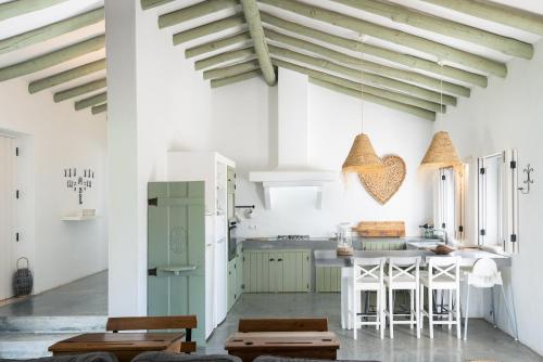 a kitchen with white walls and wooden ceilings at Herdade do Frei Cuco in Santiago do Cacém