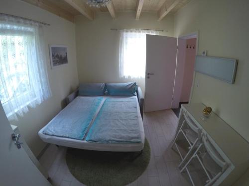 a small bedroom with a bed and a window at Zimmer am Waldeck in Langenargen