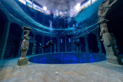 um quarto com uma piscina de água numa caverna em Friendly Cityhotel Oktopus em Siegburg