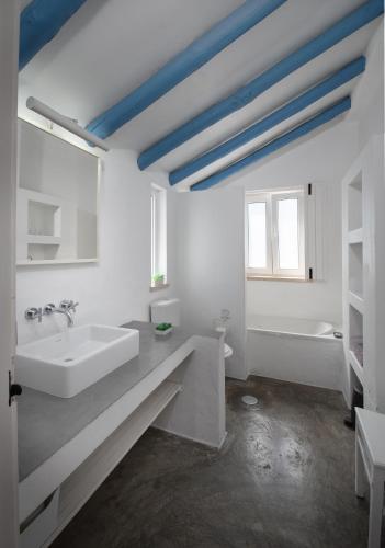 a white bathroom with a sink and a tub at Herdade do Frei Cuco in Santiago do Cacém