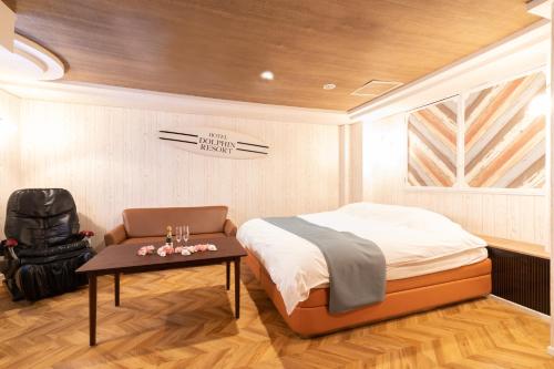 1 dormitorio con 1 cama, 1 mesa y 1 silla en 犬山ドルフィンリゾート各務原店-大人専用-, en Kakamigahara