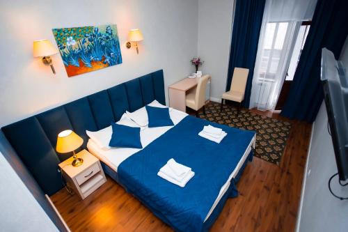 a bedroom with a blue bed in a room at Aruna Hotel in Astana