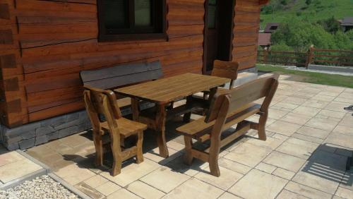 a wooden table and chairs on a patio at Roháčske zruby 2,3,4 in Zuberec