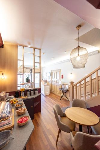 une cuisine et un salon avec une table et des chaises dans l'établissement Cit'Hotel Normandy Hotel Pornichet La Baule, à Pornichet