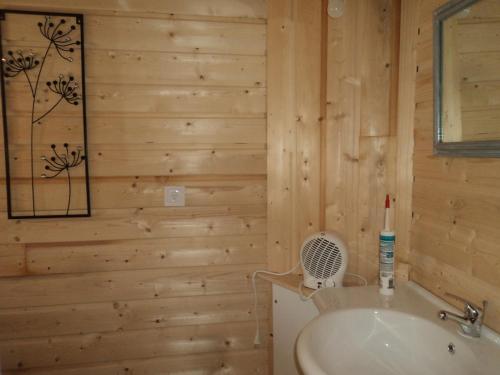 a bathroom with wooden walls and a sink at La Bastide de la Reine Margot in Beaumont
