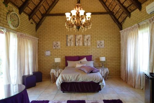 a bedroom with a large bed and a chandelier at Thabong Bed and Breakfast in Brakpan