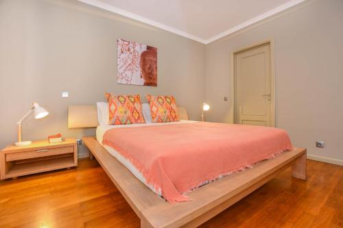 a bedroom with a large bed with orange comforter at Apartamento Costa Do Sol in Funchal