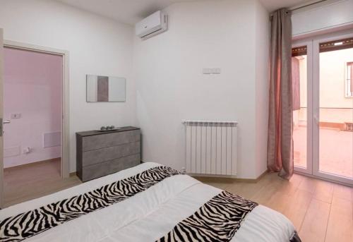 łóżko z wzorem zebry w sypialni z oknem w obiekcie Le bougainvillea 1 w mieście Corbetta