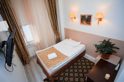 a small room with a bed and a window at Aruna Hotel in Astana