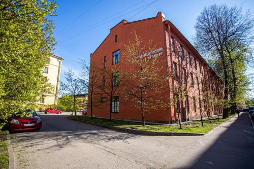 een rood bakstenen gebouw aan de kant van een straat bij Petrovskiy Art Loft in Sint-Petersburg