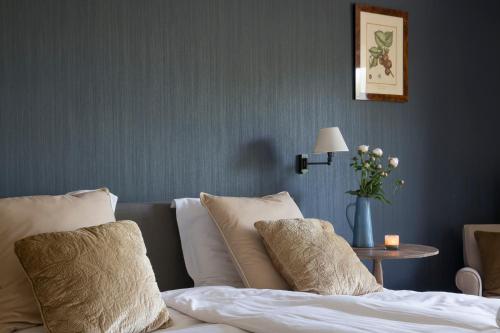 a bedroom with a bed and a table with a vase of flowers at B&B Het Soetewater in Beernem