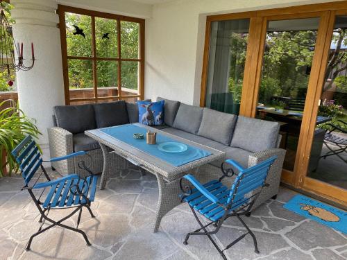 eine Terrasse mit einem Tisch, Stühlen und einem Sofa in der Unterkunft Ferienwohnung AlMa in Pflach