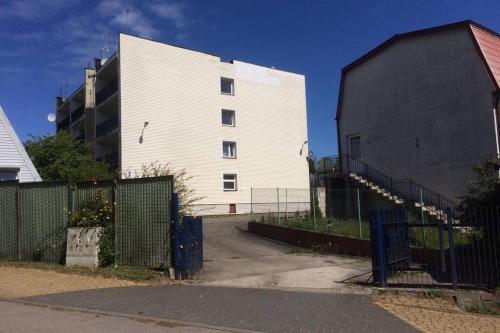 un edificio blanco al lado de una valla al lado de un edificio en Apartament Leśna Jarosławiec, en Jarosławiec