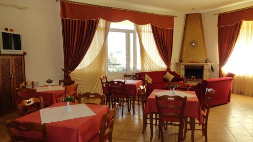 a restaurant with tables and chairs and a fireplace at Hotel Kastro in Sérvia