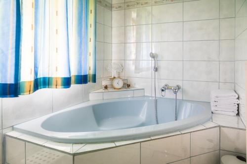 ein weißes Bad mit einer Badewanne in einem Zimmer in der Unterkunft Bio Bauernhof Oberbenk in Wagrain