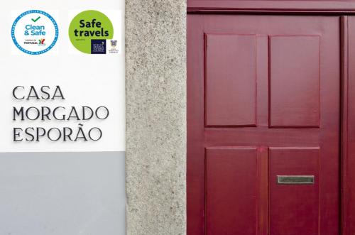 a red door next to a sign on a building at Casa Morgado Esporao in Évora