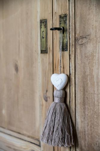 a heart shaped object hanging on a wooden door at B&B Het Soetewater in Beernem