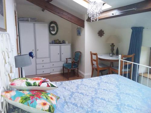 a bedroom with a bed and a table and chairs at Le Patronage in Bazoges-en-Pareds