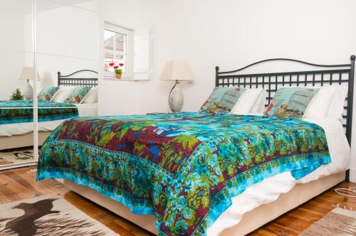 een slaapkamer met een bed met een kleurrijk dekbed bij Stylish Lisbon Apartment in Alfama in Lissabon