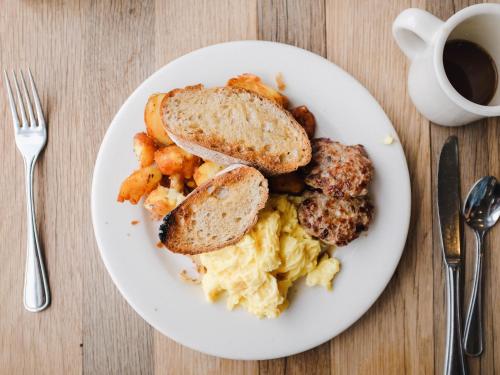 a plate of breakfast food on a table with a cup of coffee at Thabong Bed and Breakfast in Brakpan