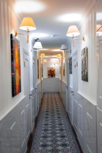 a hallway in a building with white walls and lights at Aruna Hotel in Astana